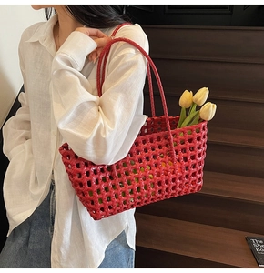 Modelweergave van een rode geweven holle tote bag met dubbele handgrepen voor strand