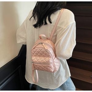 Pink quilted mini backpack with rhinestone detail shown worn on a model's back