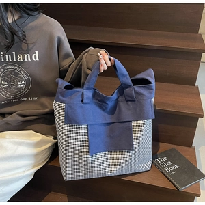 Detail of large canvas tote bag featuring navy blue and gingham patchwork design
