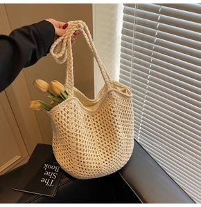 Detail of cream woven tote bag featuring hollow mesh pattern and thick braided handles