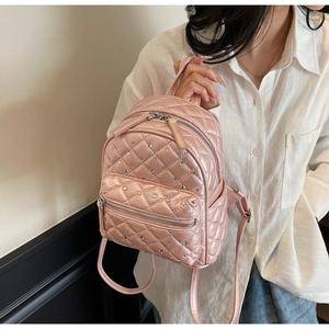 Close-up of pink quilted mini backpack with sparkling crystal embellishments and dual zippers