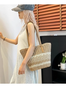 Chic woven straw tote bag with striped pattern and leather handles for beach vacation