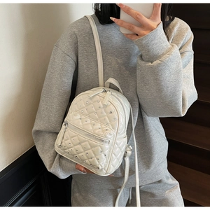Detailed shot of quilted rhombus mini backpack in cream white with sparkling rhinestones