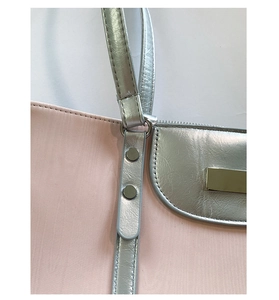 Detail view of pink textured tote bag with metallic silver flap and silver-tone hardware
