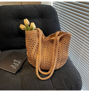 Detailed texture of a beige hollow-out woven tote bag with tulips on a velvet sofa