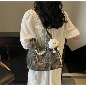 Detail of grey floral jacquard tote with leather straps, pearl chain and cloud charm