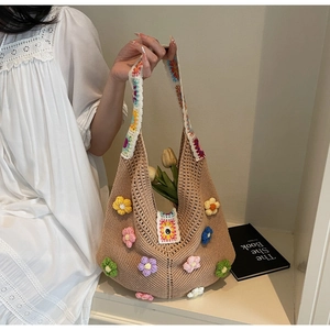 Close-up of bohemian crochet tote bag featuring 3D floral details and wide shoulder strap