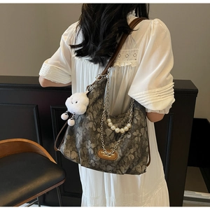 Detail of vintage floral jacquard tote with pearl chain, metal strap and cloud charm