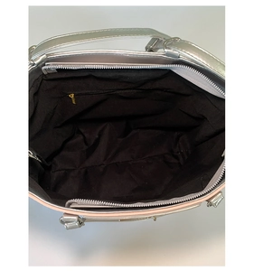 Internal view of the silver tote bag featuring black lining and a secure zipper pocket