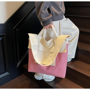 Detail shot of canvas tote bag with red gingham pattern and sturdy shoulder straps