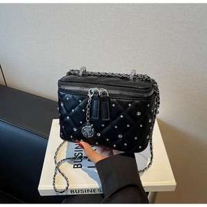 Detail of black quilted leather box bag with silver rhinestones and rose charm