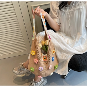 Detail of khaki crochet tote bag with colorful 3D floral accents and cotton knit texture