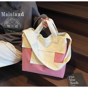 Detail of red gingham canvas tote bag showing large capacity and sturdy shoulder straps