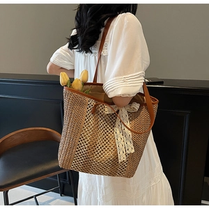 Détail du sac cabas en paille tressée avec nœud en dentelle et bandoulière en cuir chic