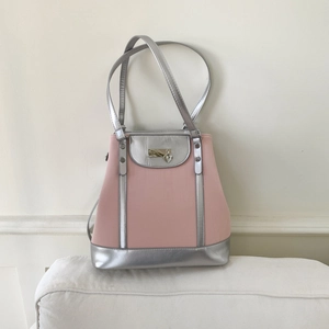 Detail of dry rose pink tote bag with silver metallic accents and heart-shaped charm