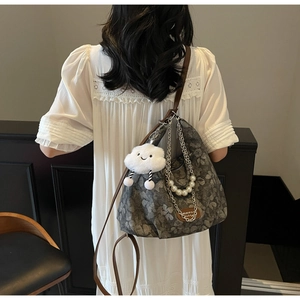 Detail view of floral tote bag with pearl chain and cute plush cloud charm detail