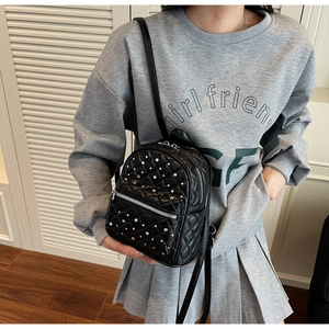 Detail of black mini quilted backpack with sparkling rhinestones and silver zipper pocket