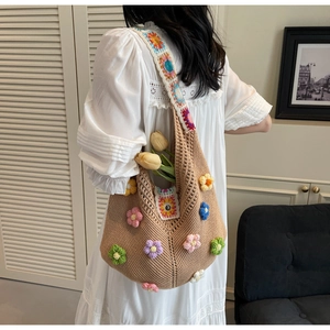 Detail of handmade crochet shoulder bag featuring colorful 3D knit floral patterns