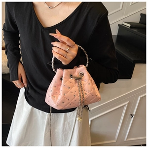 Detail of pink quilted bucket bag with rhinestones, chain drawstring and pearl accents