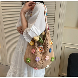 Detailed close-up of handmade beige crochet tote with colorful 3D knitted flower accents