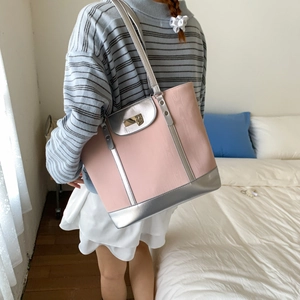 Detail of pink and silver tote bag with wood grain texture and metal twist lock closure