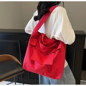 Detail of red canvas tote bag with large front pocket and versatile shoulder straps