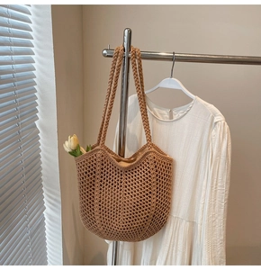 Hanging khaki knit tote bag showing hollow-out texture and thick braided handles