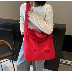 Detail of red canvas tote bag showing spacious multi-pockets and pleated fabric texture