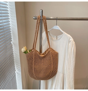 Close-up of the hollow mesh texture and woven shoulder strap on a beige tote bag