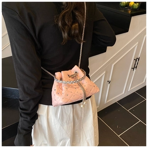 Detail of pink quilted bucket bag with silver rhinestones and pearl chain drawstring