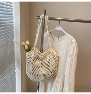 Detail of cream woven crochet tote bag with openwork pattern and inner lining