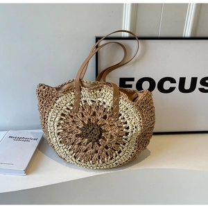 Detail of hollow-out straw tote with leather handle and round woven texture