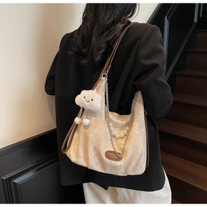 Detail of beige jacquard tote with pearl chain, metal strap and cloud charm pendant