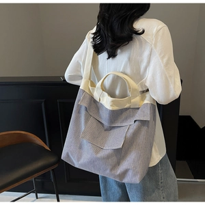 Detail view of the striped canvas tote bag showing the high-capacity design and shoulder strap