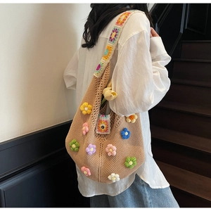 Detail of handmade knit tote with colorful 3D flowers and crochet shoulder strap