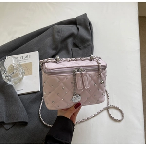 Detail of pink quilted box bag with silver chain strap and rose zipper charms