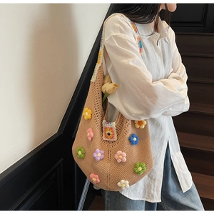 Detail of hand-woven tote bag with colorful 3D floral accents and geometric strap