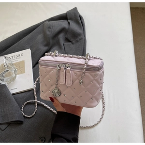 Detailed shot of pink quilted mini box bag with silver studs and rose metal charm