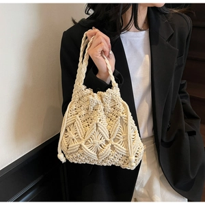 Détail du sac seau en macramé crème avec motifs tissés complexes et cordon de serrage