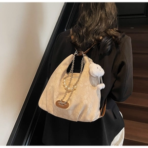 Detail of beige jacquard hobo bag with floral patterns, metal chain and pearl decor