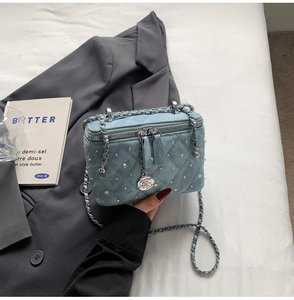 Blue denim quilted bag with silver rivets, rose pendant and chain strap detail