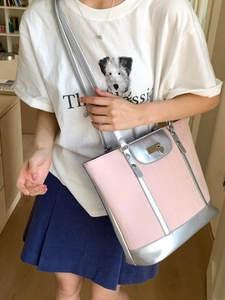 Pink and silver tote bag with heart charm shown on model for daily commuting style