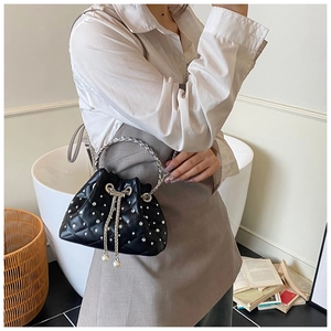 Detail of quilted bucket bag with silver rhinestones, metal handle and pearl drawstring