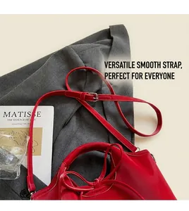 Detailed shot of the red faux leather shoulder bag with adjustable strap and silver buckle