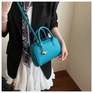 Close-up of litchi texture leather tote bag in lake blue with silver whale pendant