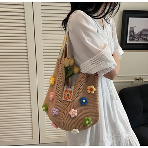 Detail of bohemian knit tote bag with colorful 3D crochet floral patterns and sturdy strap