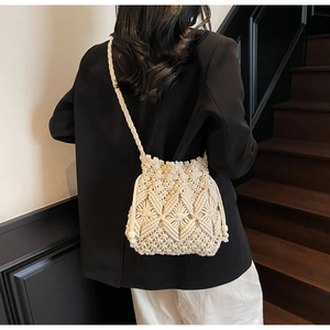 Détail d'un sac seau tissé crème avec motif ajouré complexe pour les vacances à la plage