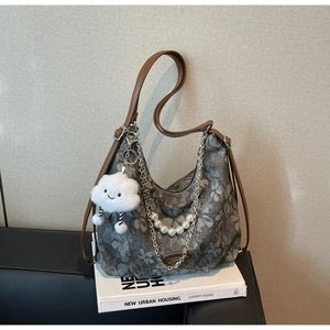 Detail view of floral jacquard bag with pearl charms and silver chain strap