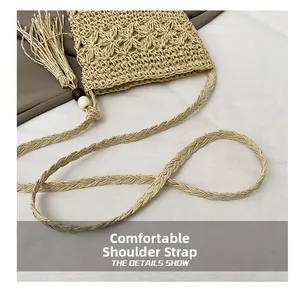 Detail of hand-woven shoulder strap and decorative tassel on straw beach bag