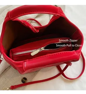 Detail of red leather bucket bag with smooth zipper inner pouch and brown lining